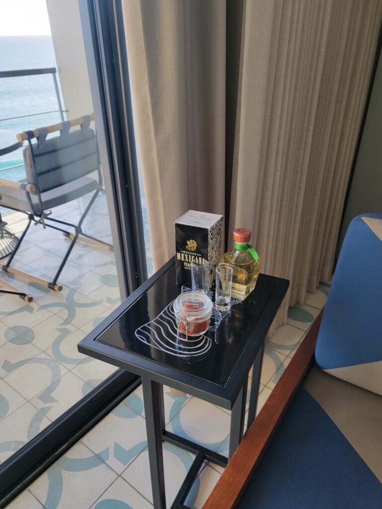 a table with a glass bottle and a box of food on it