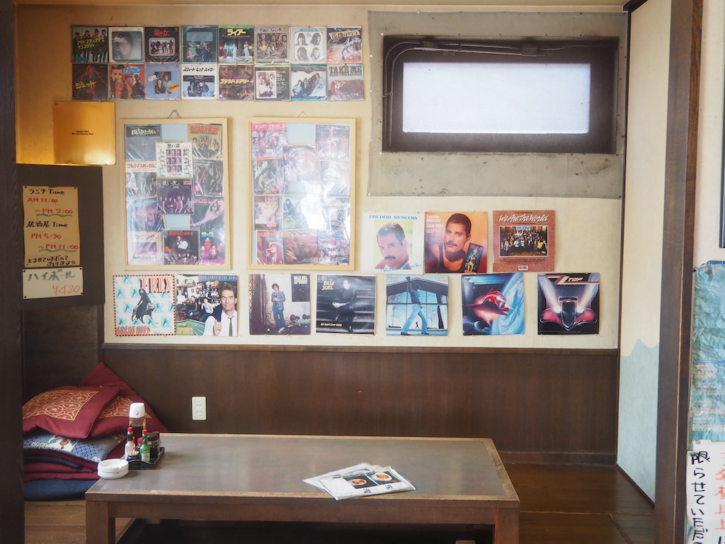 a room with a table and posters on the wall