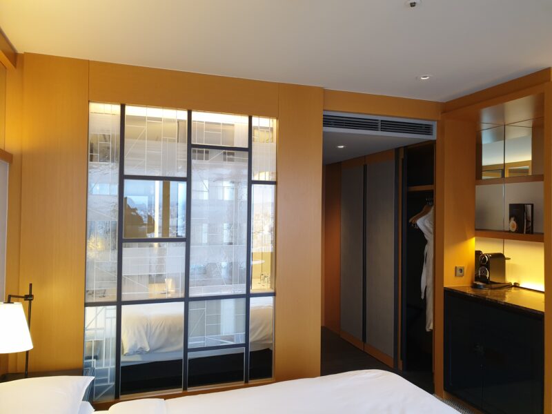 a room with a bed and a window with glass doors