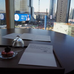 a table with a plate of fruit and a glass bowl with a city skyline in the background
