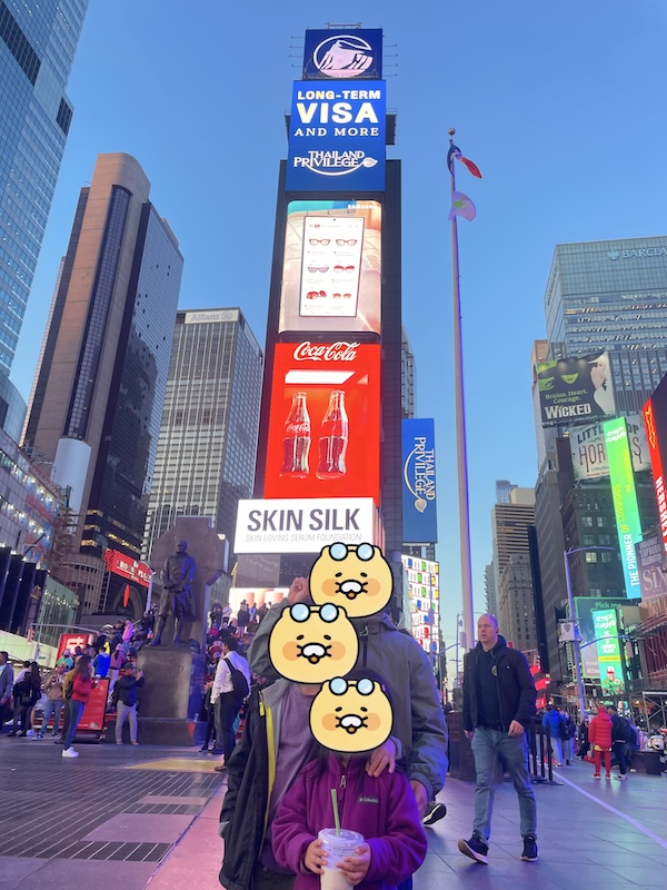 a large sign with a cartoon character on it with Times Square in the background
