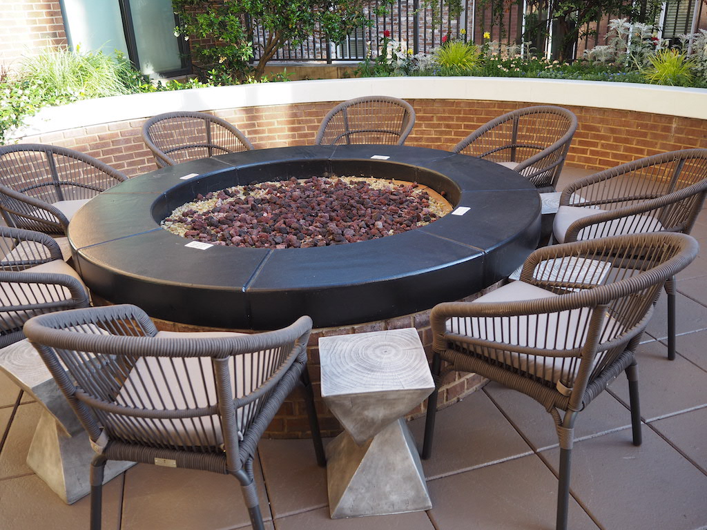 a round black grill with a round black grill and chairs around it