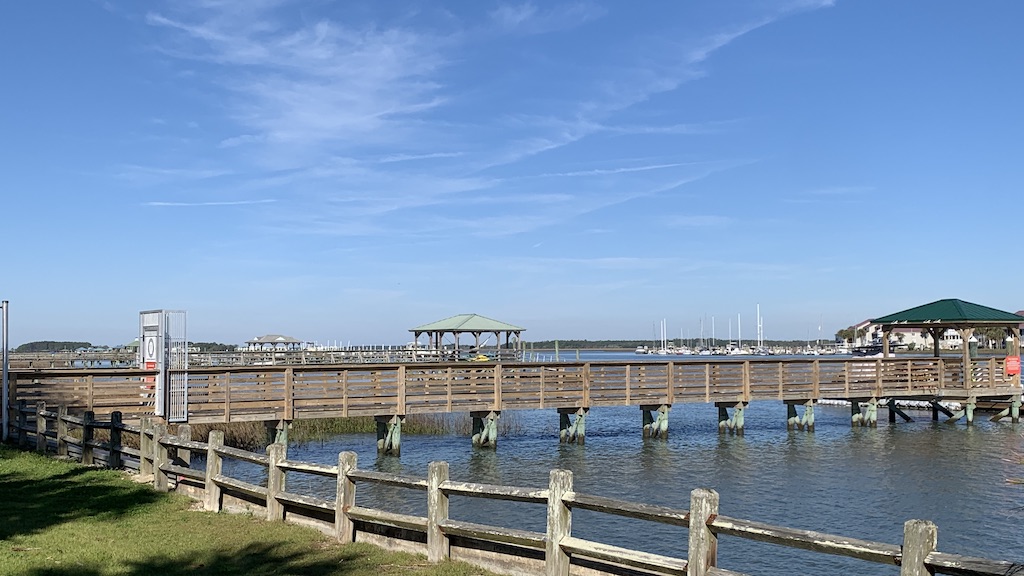 a dock with a body of water and a building in the background