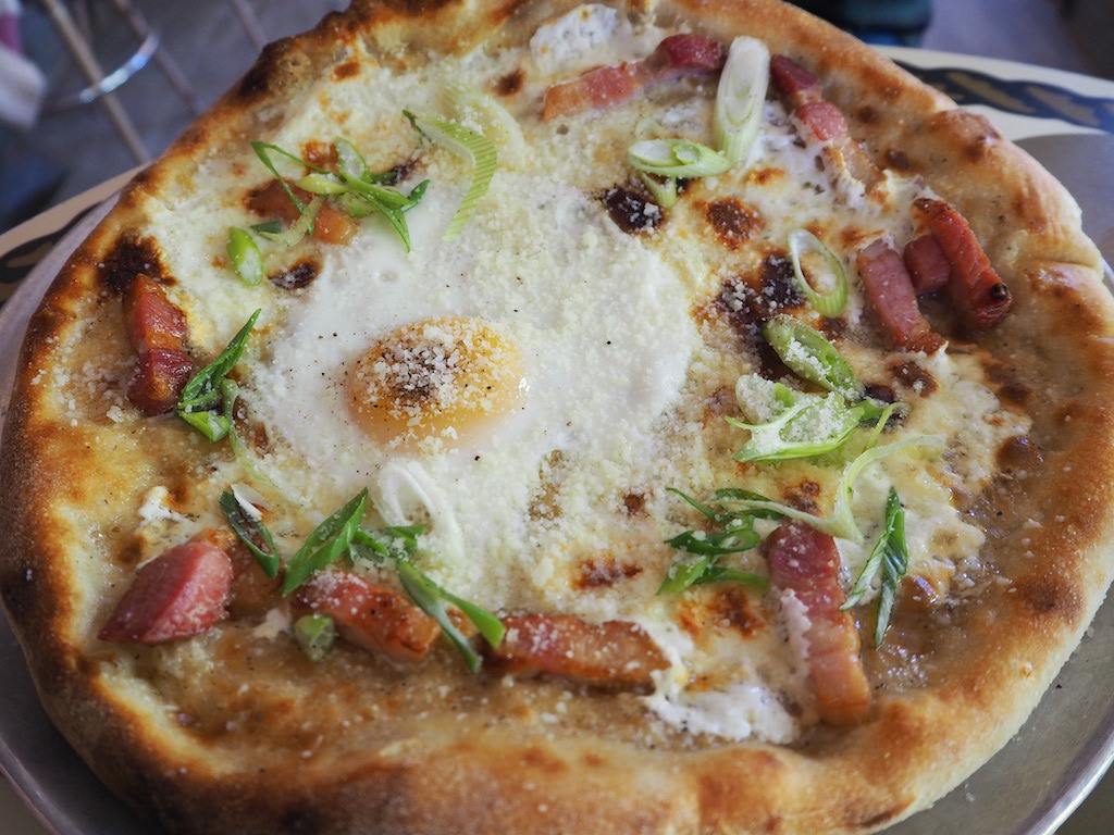 a pizza with eggs and bacon