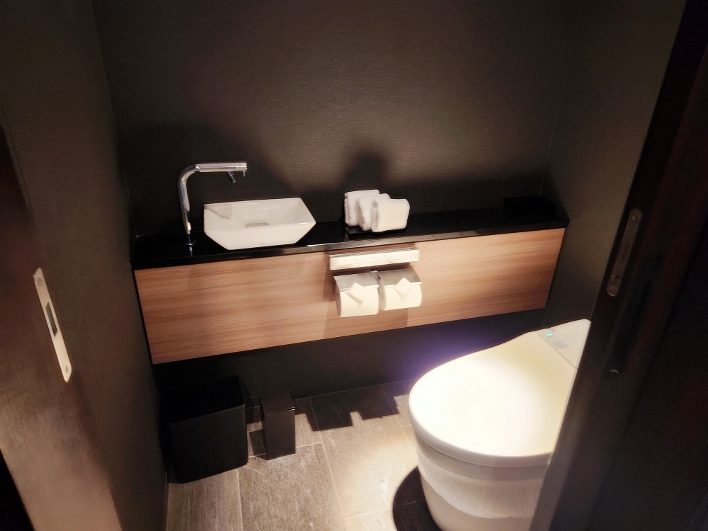 a bathroom with a sink toilet and a shelf