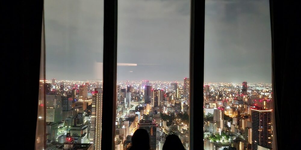 a group of people looking out a window at a city