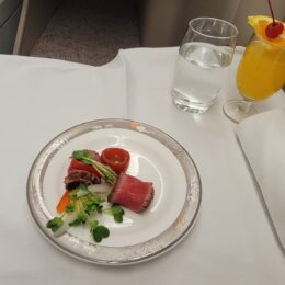 a plate of food and glasses of juice on a table