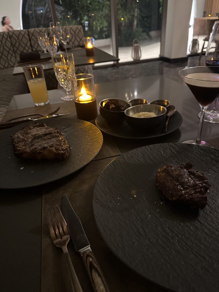 a table with plates of food and glasses of wine