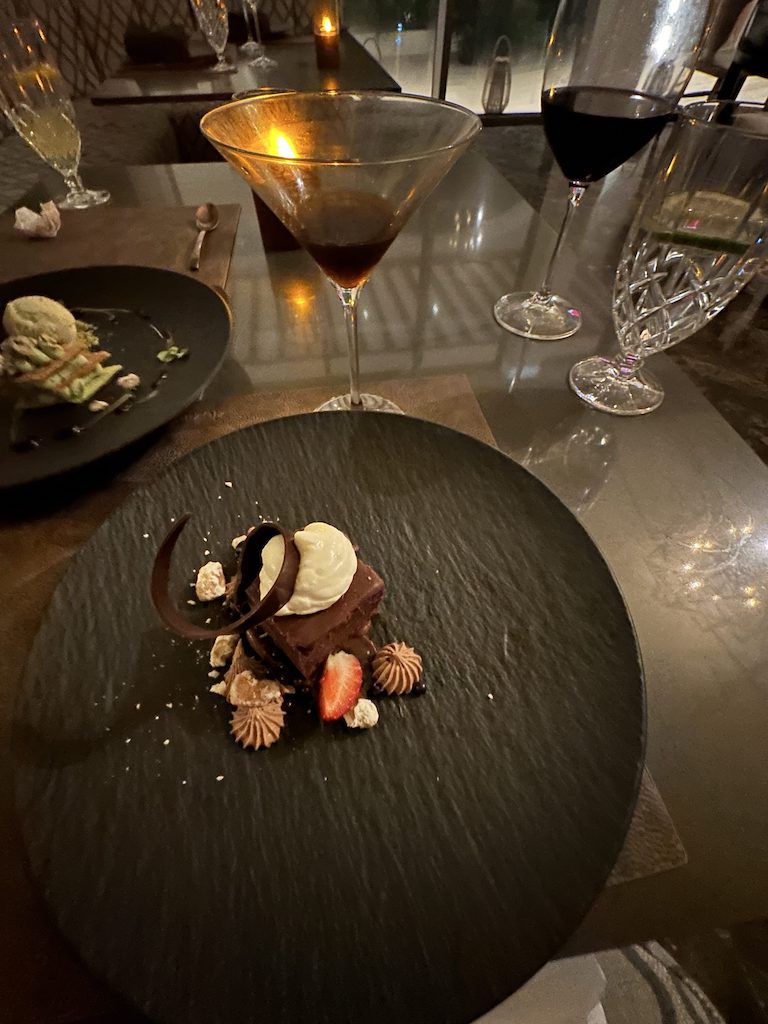 a plate of food and glasses of wine on a table