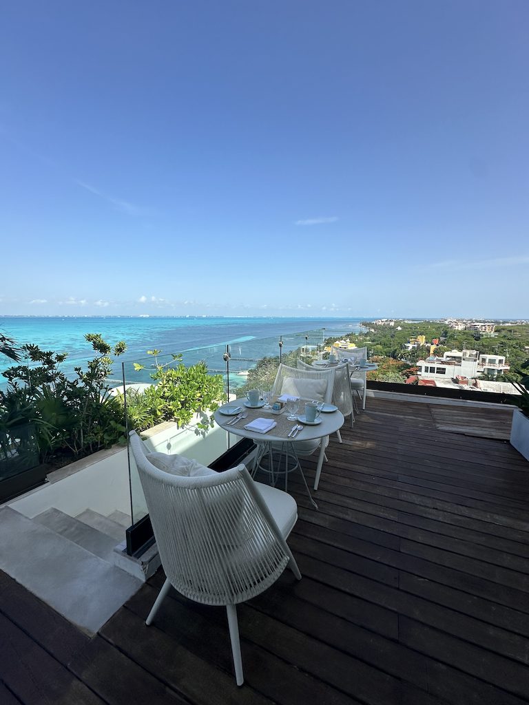 a table and chairs on a deck overlooking a body of water