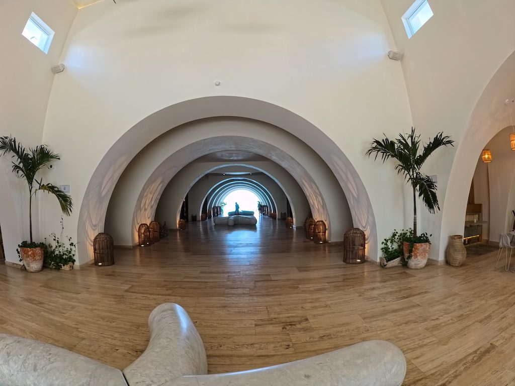 a room with a wood floor and a large arched doorway