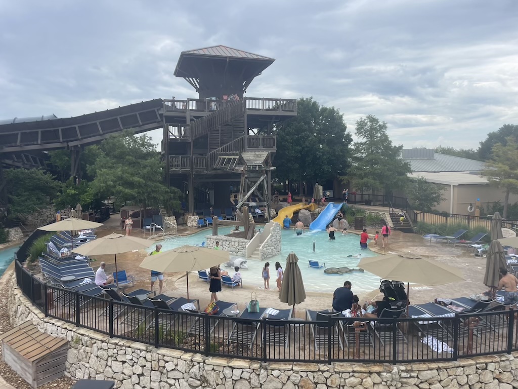 a water park with people and a ferris wheel in the background