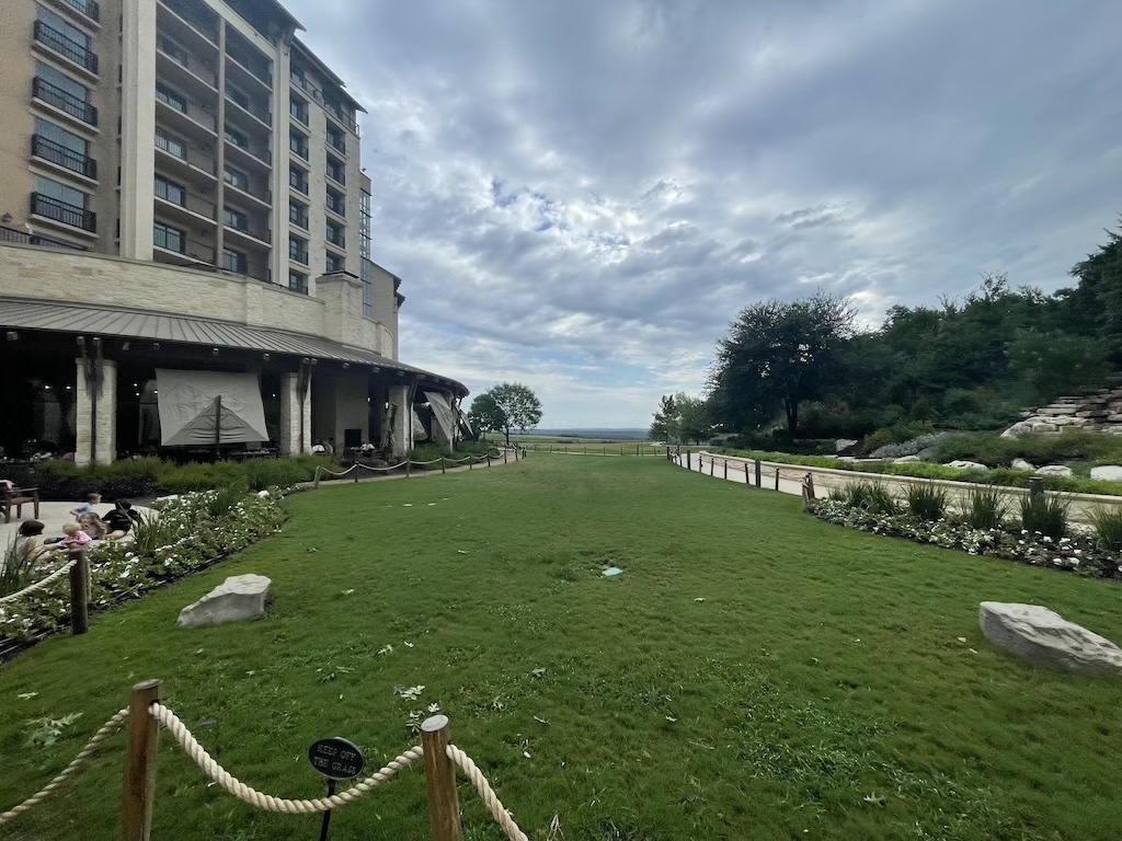 a grassy area with a building in the background