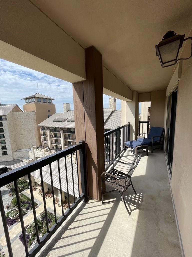 a balcony with chairs and a railing