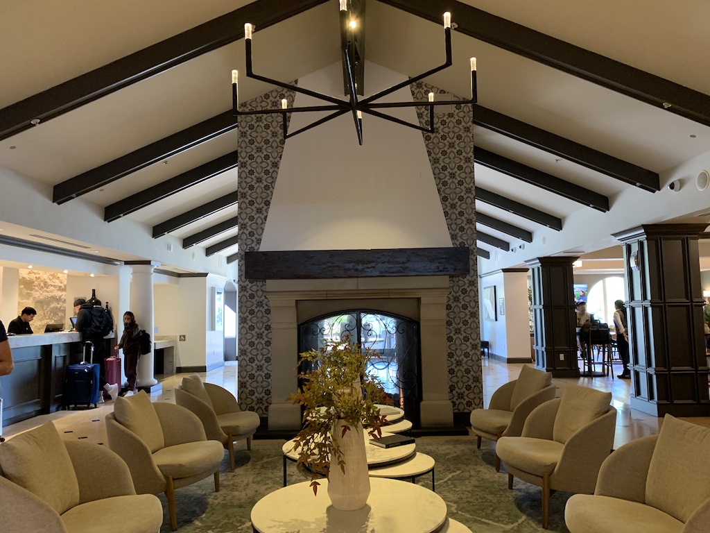 a room with a large chandelier and a table with chairs