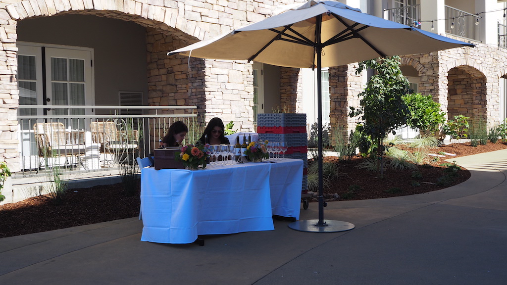 a couple of people sitting at a table under an umbrella