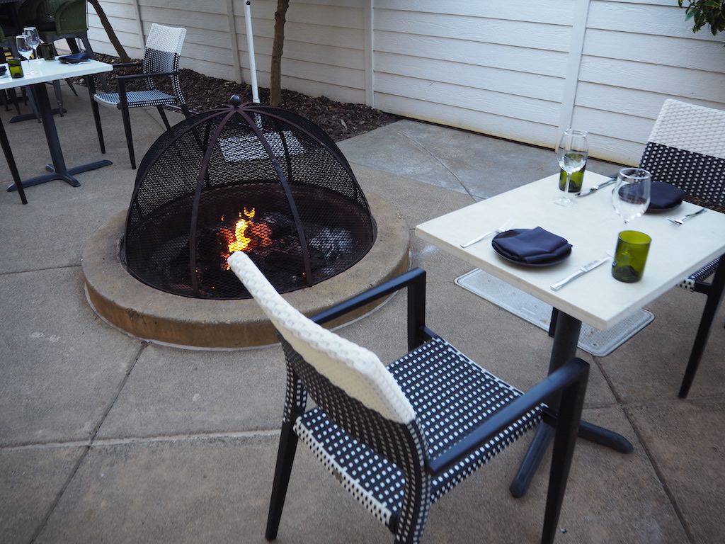 a fire pit with a table and chairs around it