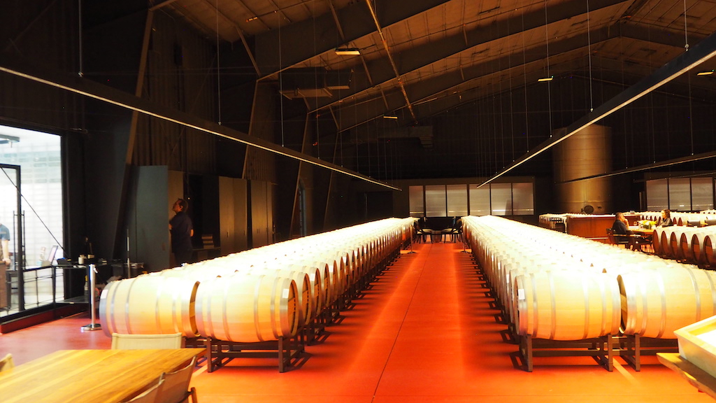 a person standing next to a large white barrel in a room with windows