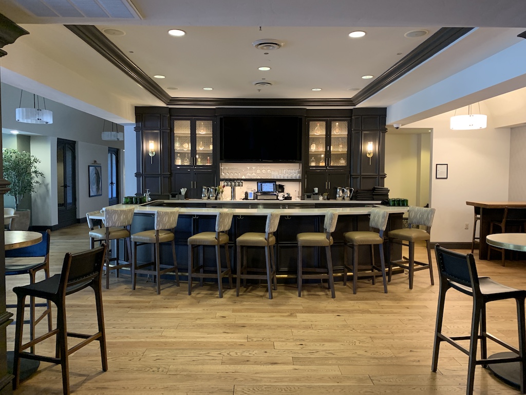 a large kitchen with a bar and chairs