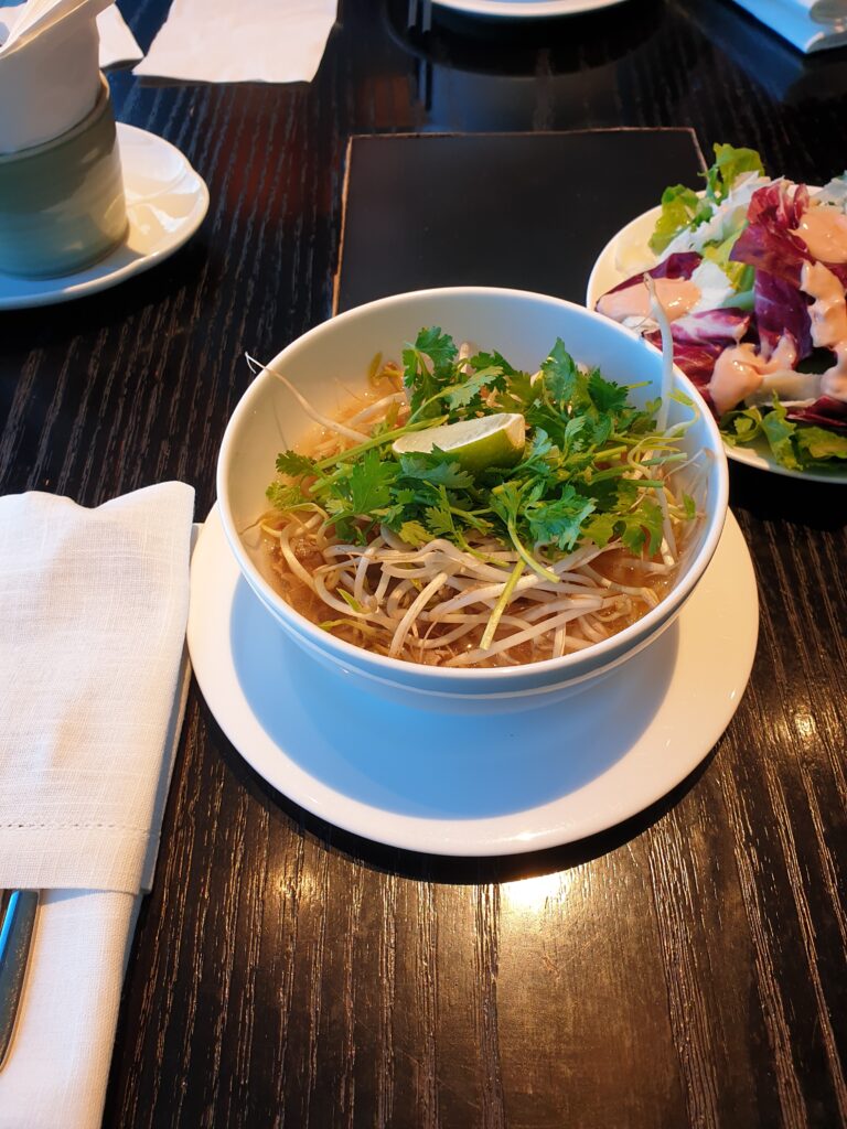 a bowl of noodles and salad