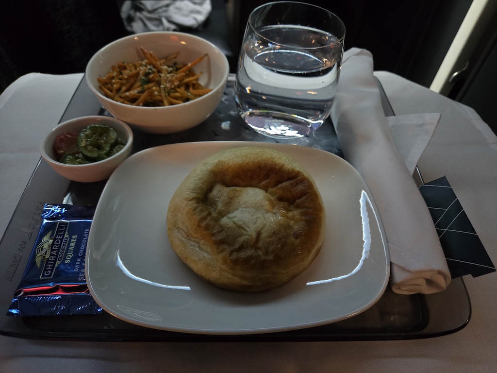 a plate of food and a glass of water on a tray