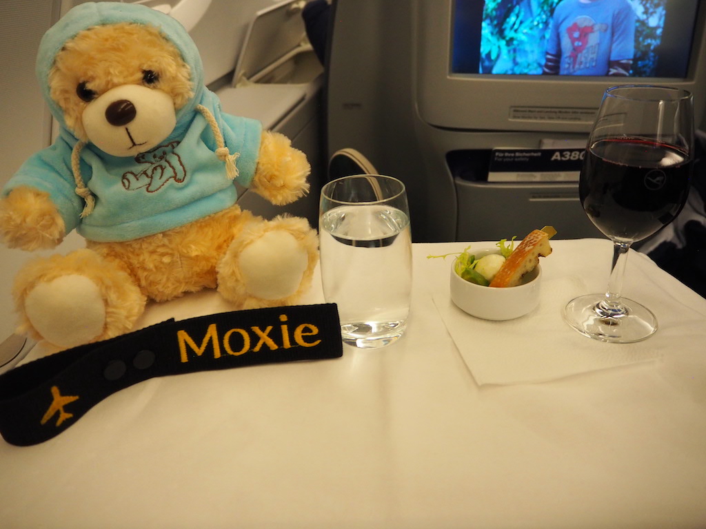 a teddy bear next to a glass of wine