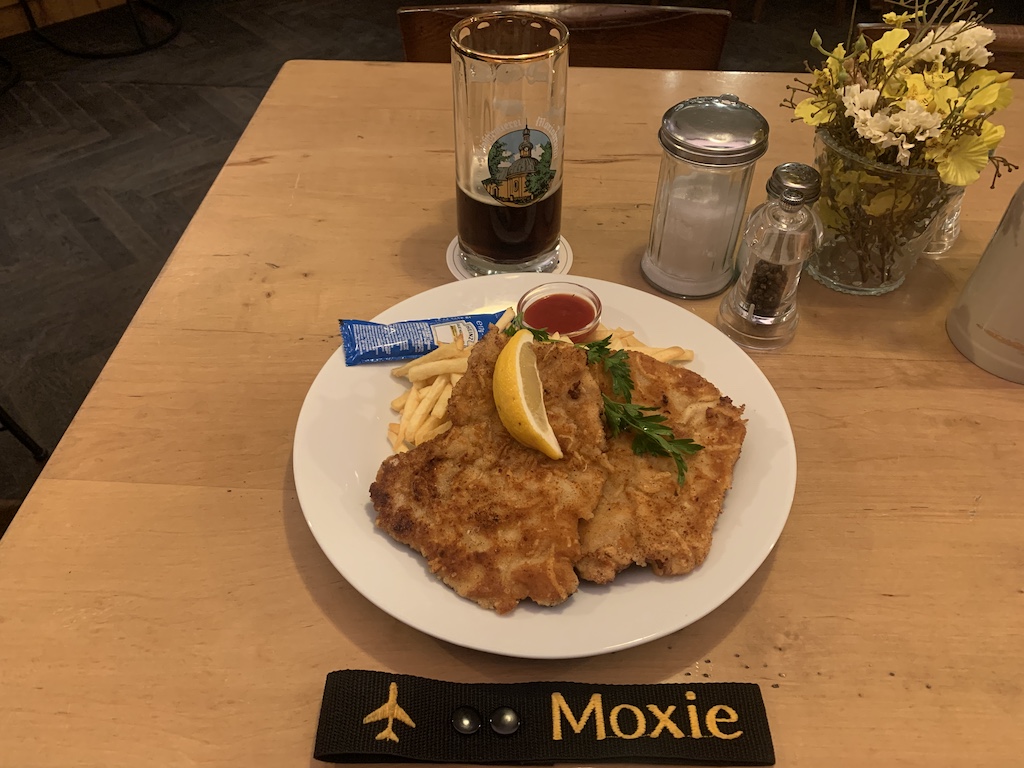 a plate of food and a glass of beer on a table