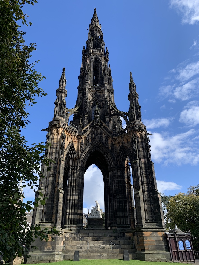 a large stone building with Scott Monument in the background