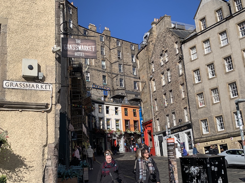 a group of people walking on a street between buildings