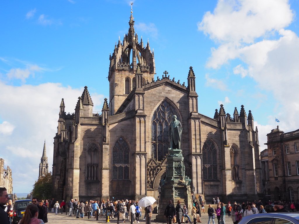 a large cathedral with many people walking around with St Giles' Cathedral in the background