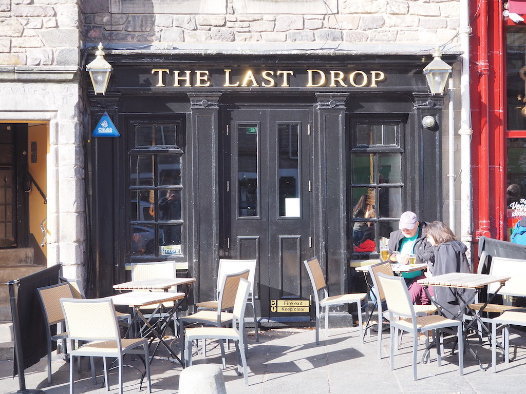 a couple of people sitting at a table outside a restaurant