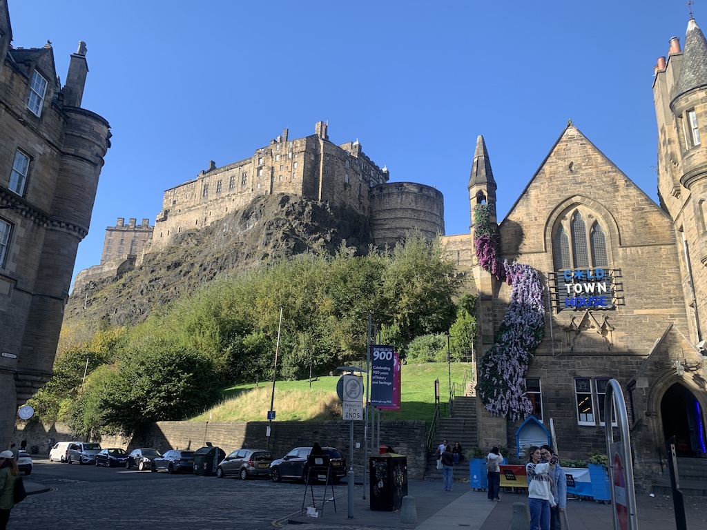 a large stone building with a hill in the background