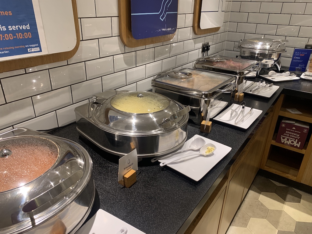 a kitchen with many pots and pans on the counter