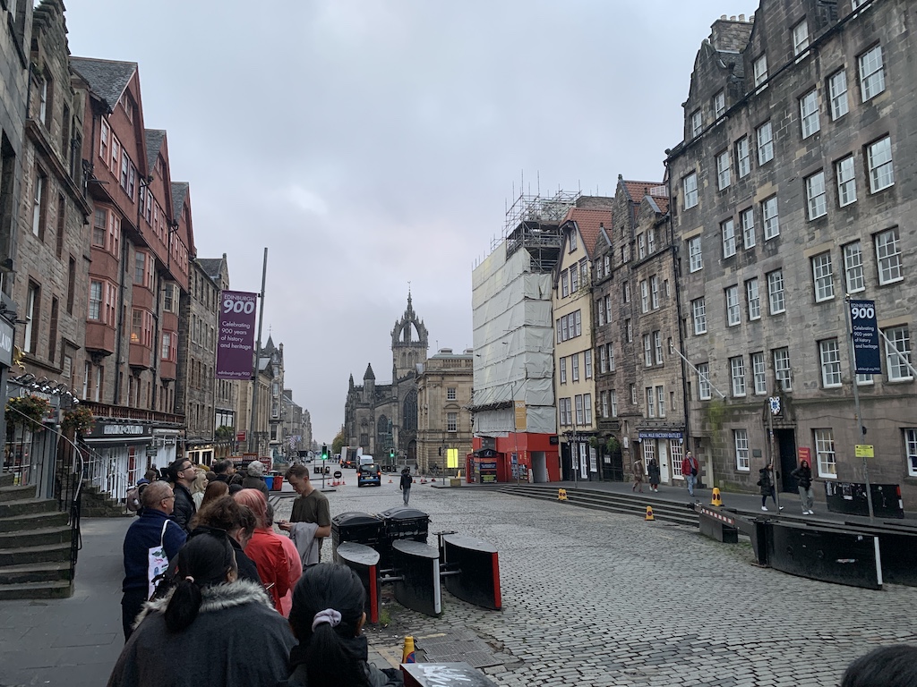 a group of people walking on a street between buildings