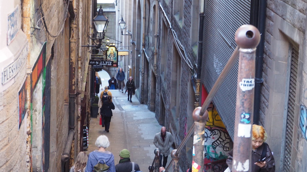 people walking down a narrow street