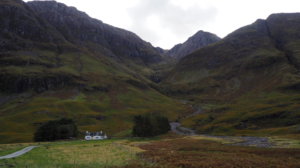 a house in a valley between mountains