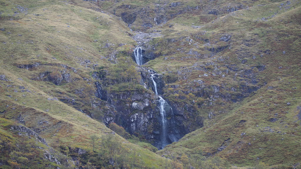 a rocky cliff with a waterfall