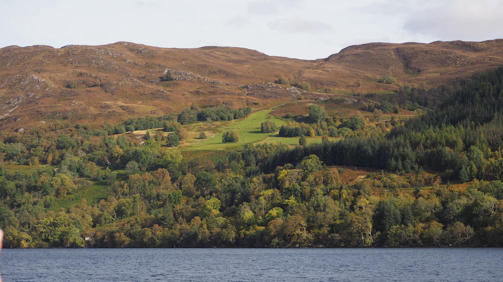 a body of water with trees and hills in the background