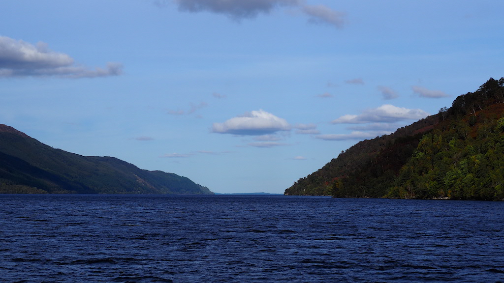 a body of water with hills in the back