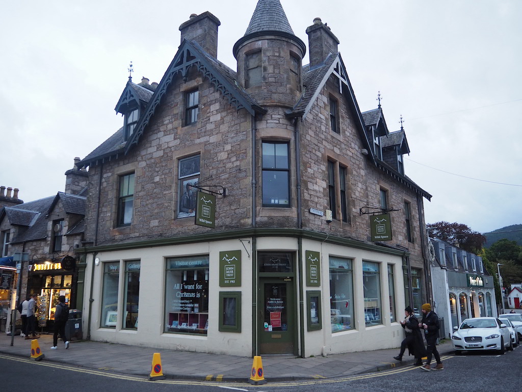 a building with a street and people walking by it