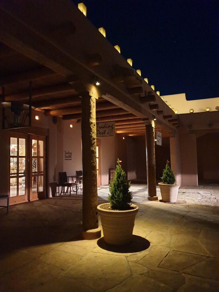 a building with a large pillar and a planter with a plant in it