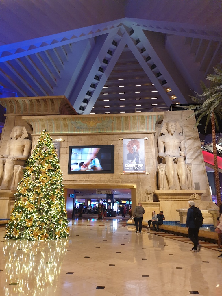 a large room with a large statue and a tree in it