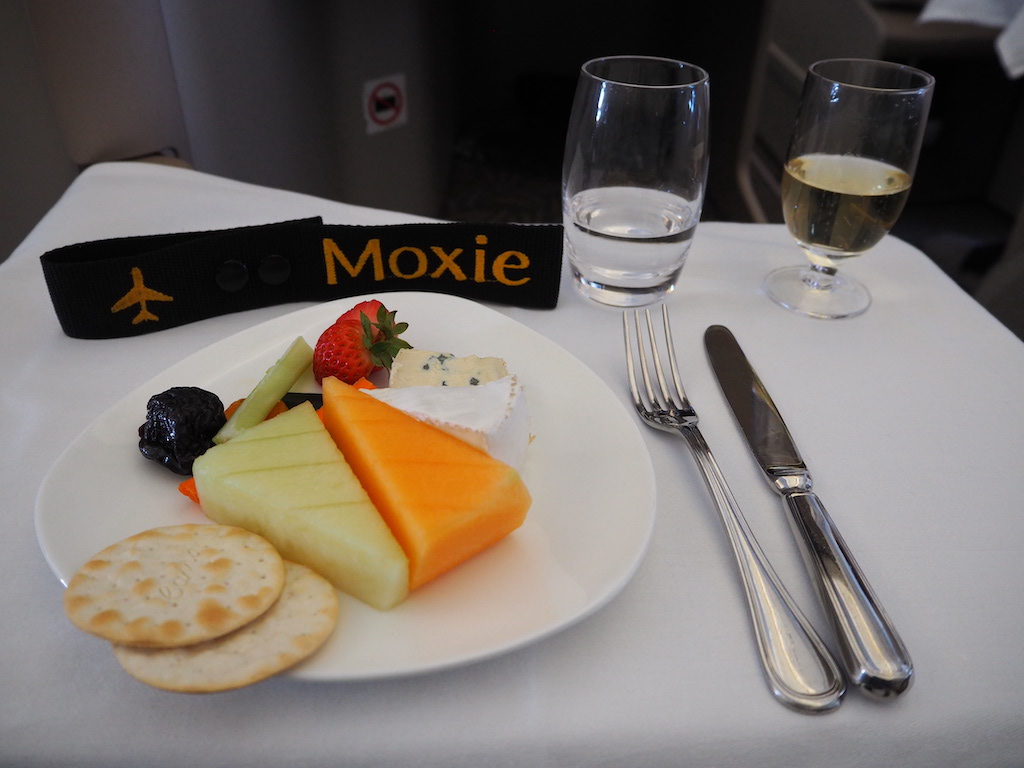 a plate of food and glasses of wine on a table