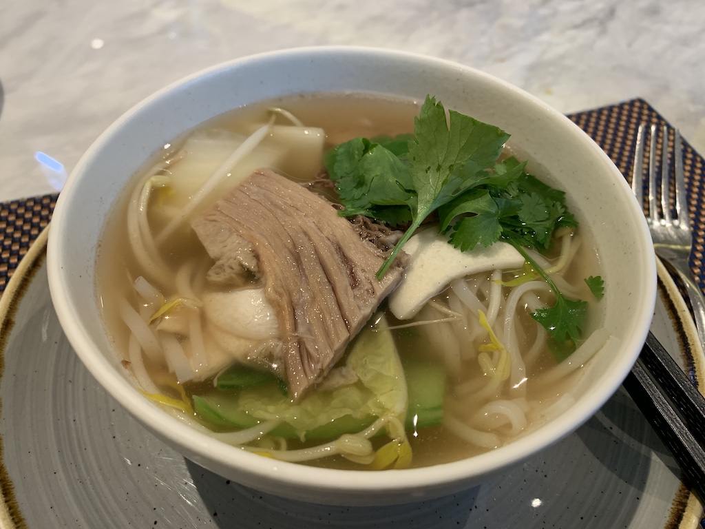 a bowl of soup with a piece of meat and vegetables