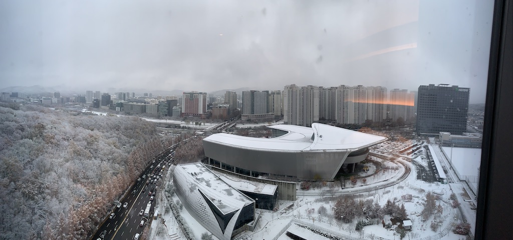 a large building with a roof and a city in the background