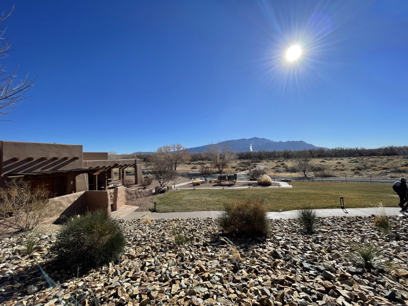 a building with a large yard and a large field with a mountain in the background