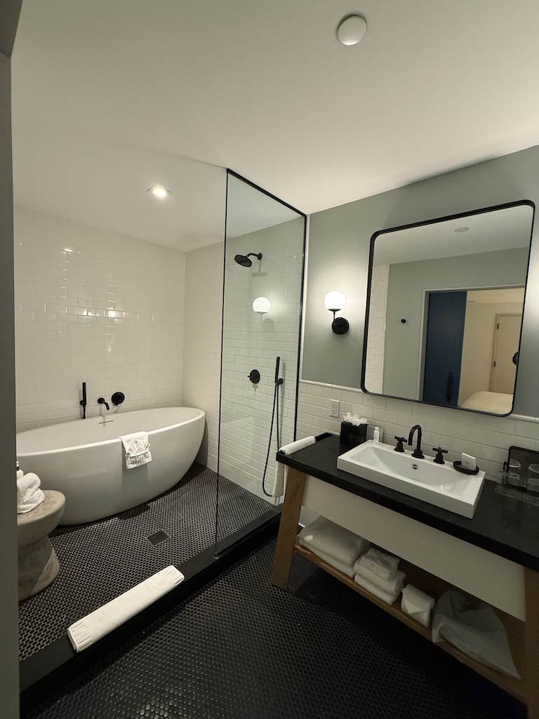 a bathroom with a tub sink and mirror