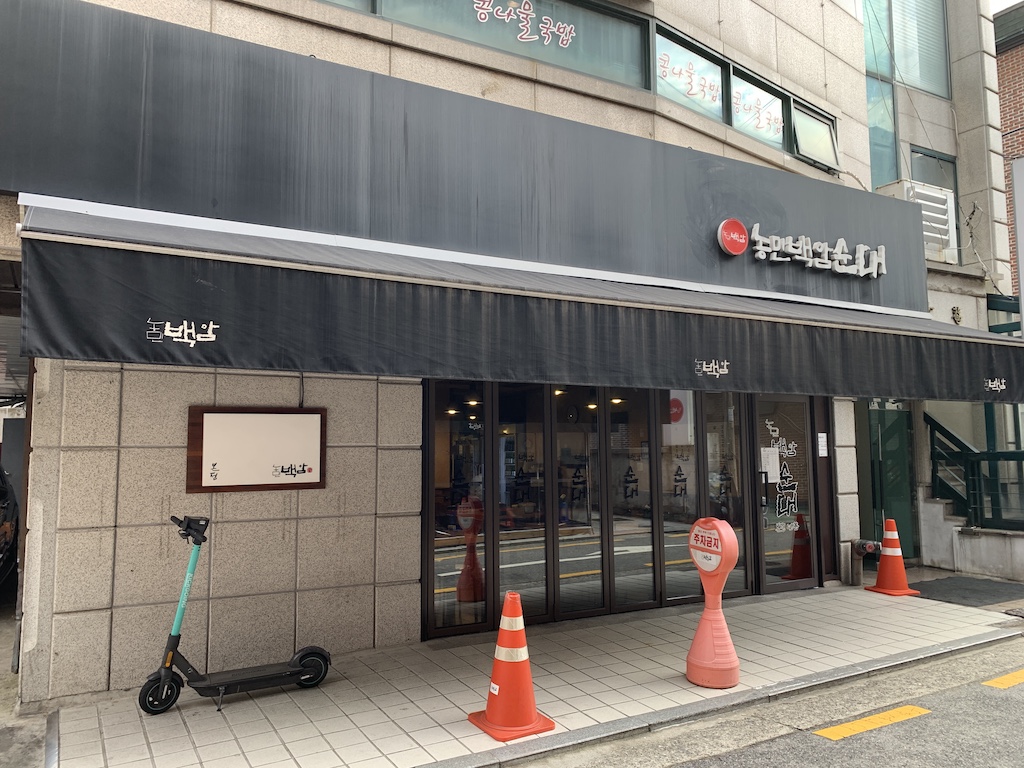 a building with a black awning and a cart in front of it