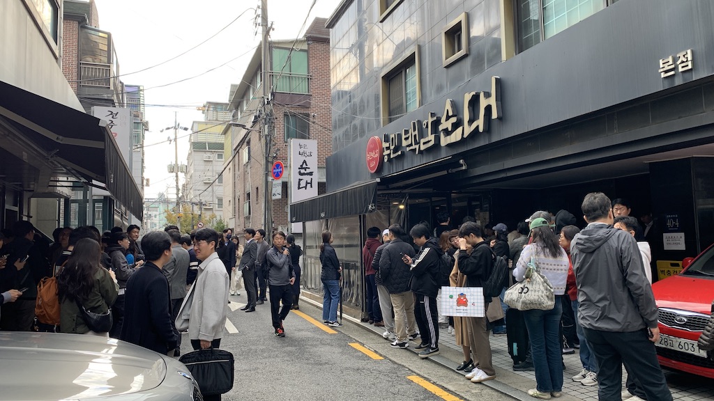 a group of people standing on the side of a street