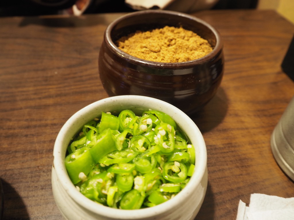 a bowl of soup next to a bowl of rice and a bowl of soup